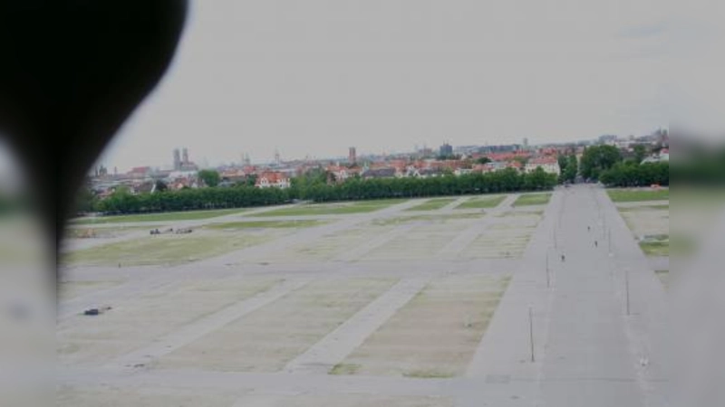 Der Blick aus dem Kopf der Bavaria über die unbelebte Theresienwiese trügt. Ende Juli wird der Aufbau der Zelte und Fahrgeschäfte beginnen. In der Zeit sollen die Anwohner  Umwege in Kauf nehmen. (Foto: tg)