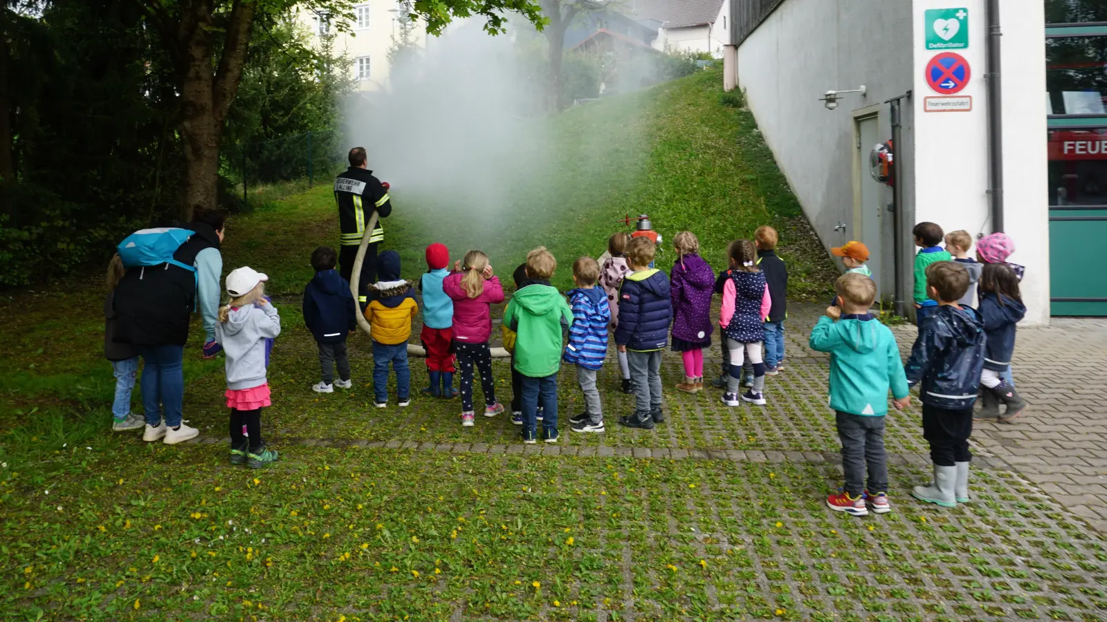 Gespannt beobachten die Kinder den Einsatz des Wasserschlauchs. (Foto: Gemeinde Alling)