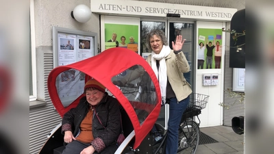 Heidi Sorgalla (links) lässt sich von Pastoralreferentin Nicola Rieß von der Erzdiözese München und Freising zur Probe in der Rikscha kutschieren. Das Rikscha-Angebot im ASZ Westend entstand in Kooperation des ASZ mit der Erzdiözese. (Foto: Celine Peiroten)