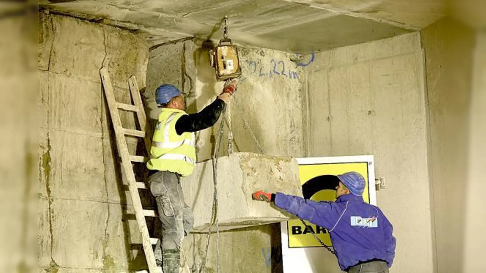 Handwerker heben einen der etwa 1.200 Kilo schweren Steinquader aus der Durchbruchstelle im U-Bahnhof Olympia-Einkaufszentrum. 	 (Foto: VA)