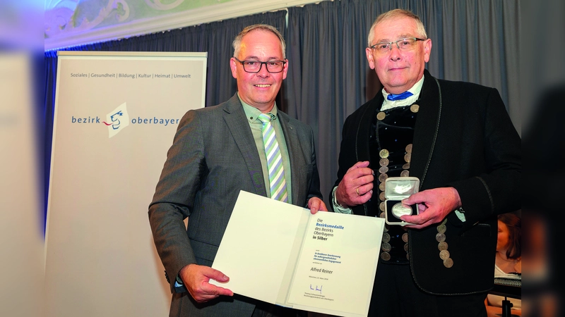 Bezirkstagspräsident Thomas Schwarzenberger (links) überreichte die Auszeichnung an Alfred Reiner. (Foto: Wolfgang Englmaier)