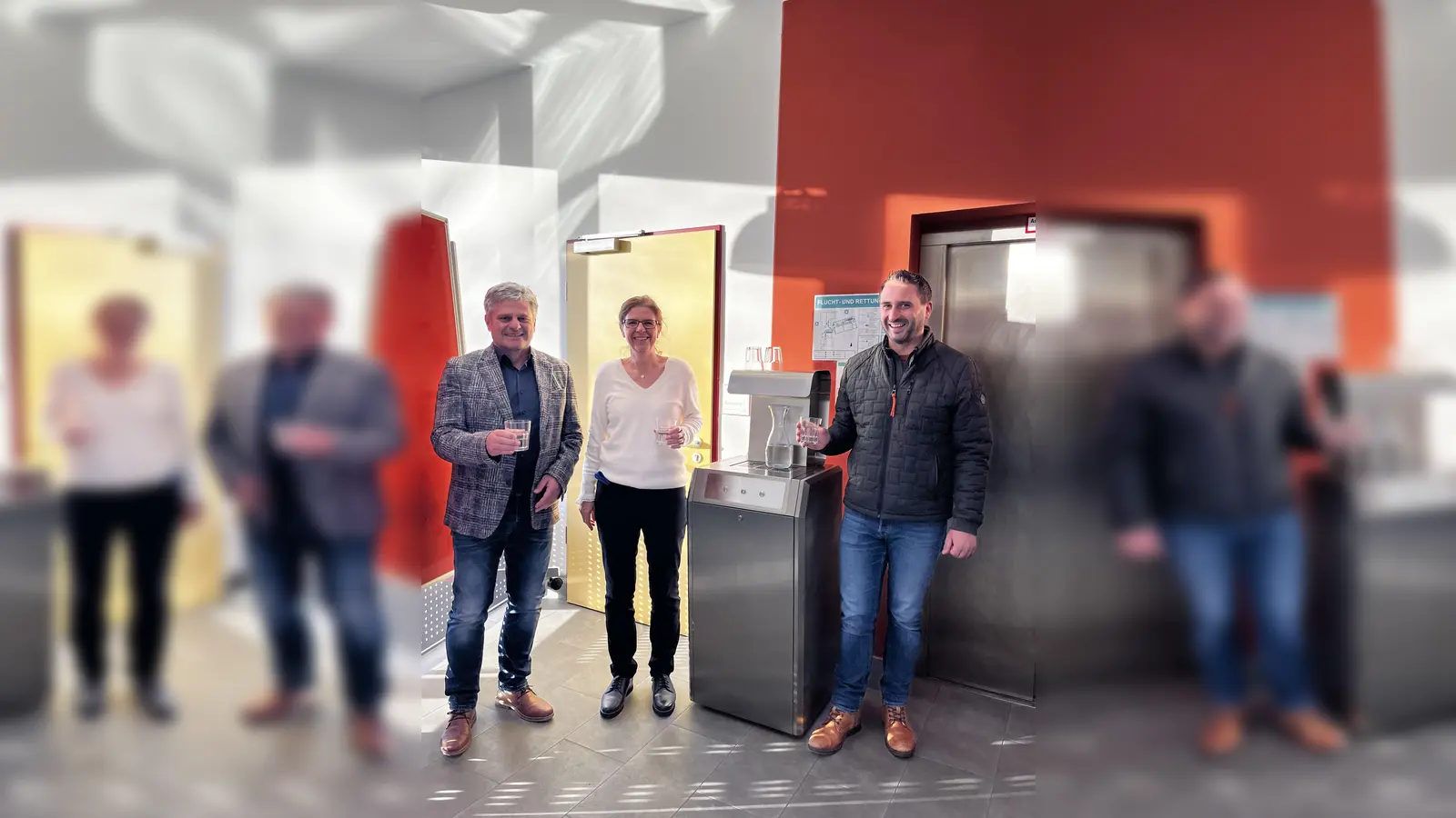 Wasser ist ein Lebensexilier: In der Aula, gleich beim Eingang steht nun der Trinkwasserautomat. Schulleitung Katharina Fürst (Mitte), Bürgermeister Stefan Joachimsthaler (links) und Amtsleiter Benedikt Friedinger (rechts) probieren gleich die Wasservarianten – still, gesprudelt oder extrakühl, oder Mischungen daraus.  (Foto: Gemeinde Alling)