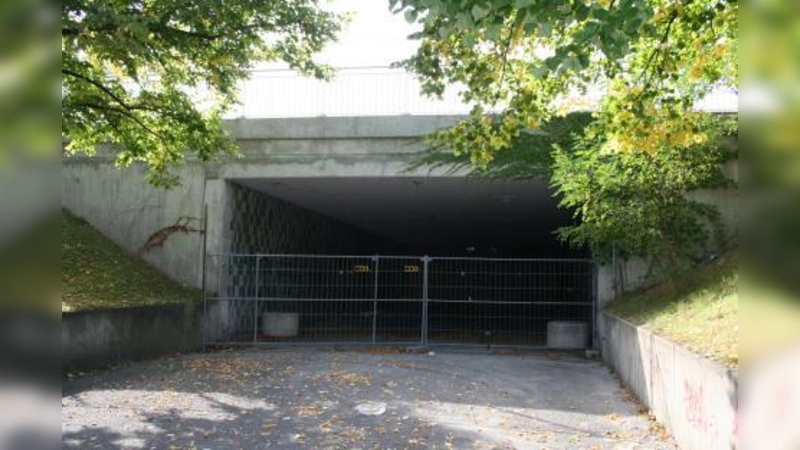 Radler und Fußgänger blicken beim Tunnel an der Theresienwiese in ein dunkles Loch. Die Hälfte der Unterführung ist mit Sand und Schotter zugeschüttet. (Foto: tg)