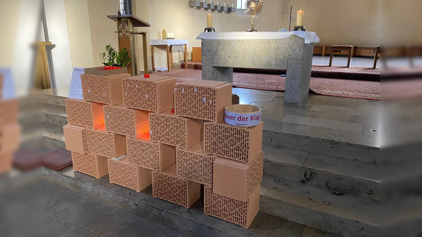 In die aus Ziegelsteinen aufgestellt Mauer in St. Ulrich können Klagen, Bitten oder Gebete abgelegt werden. (Foto: Heinz-J.Haury)