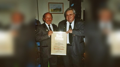 Aus den Händen seines Nachfolgers Georg Hardt erhält hier Reinhold Fritzenwanker (rechts) seine Urkunde mit der Ernennung zum Ehrenschützenmeister. (Foto: SG Langwied)