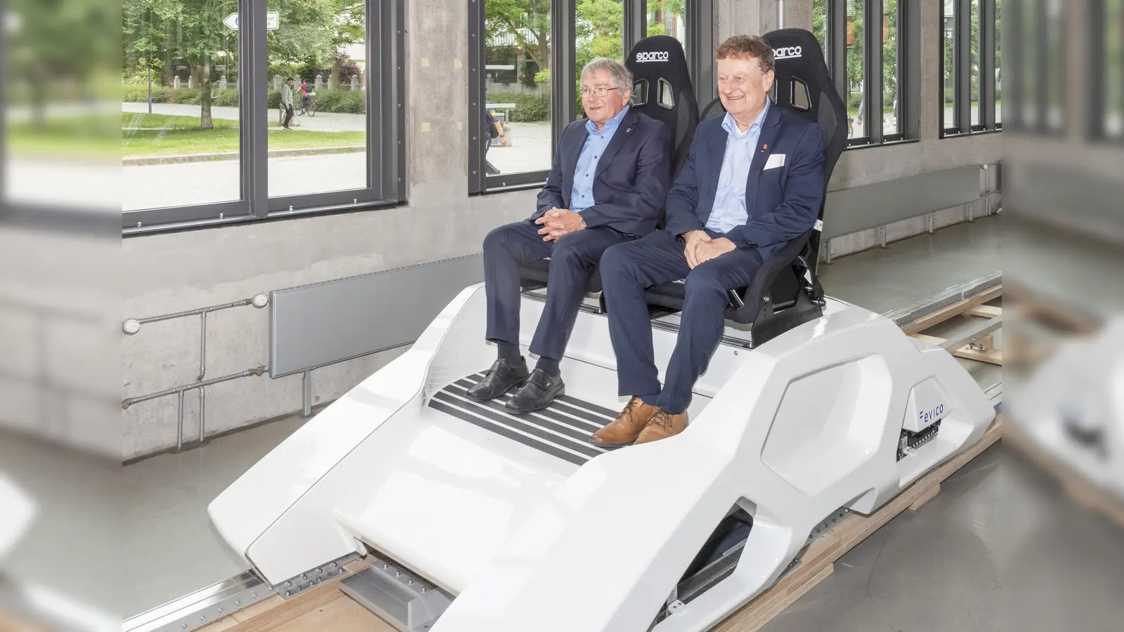 Völlig losgelöst im Verkehrszentrum: Physik-Nobelpreisträger Georg Bednorz (li.) und Generaldirektor Wolfgang M. Heckl genießen das „erhebende Gefühl” im Supra-Gleiter. Die Demonstrationsanlage mit dem Schlitten, der mithilfe von supraleitenden Materialien über einer Schiene schwebt, befindet sich am Ende der Halle I. (Foto: Hubert Czech, Deutsches Museum)