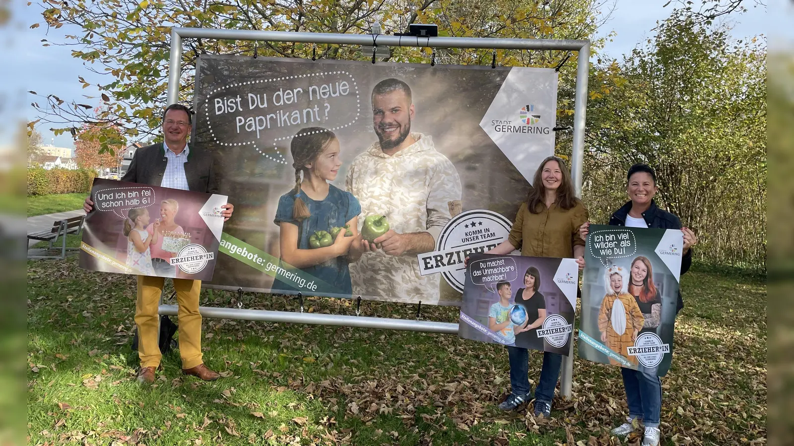 Mit diesem Plakat, das am Ortseingang nach Germering steht, soll das Interesse bei potenziellen Bewerbern für einen Kita-Job geweckt werden, v.l.: Oberbürgermeister Andreas Haas, Sandra Bartler und Martina Klein.  (Foto: Patrizia Steipe)