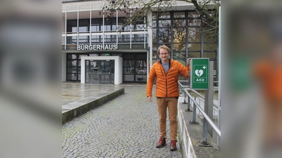 Bürgermeister Sebastian Thaler neben dem lebensrettenden Defibrillator, der vor dem Bürgerhaus, links neben den Infotafeln, steht.  (Foto: Gemeinde Eching)