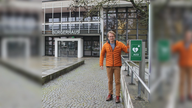 Bürgermeister Sebastian Thaler neben dem lebensrettenden Defibrillator, der vor dem Bürgerhaus, links neben den Infotafeln, steht.  (Foto: Gemeinde Eching)