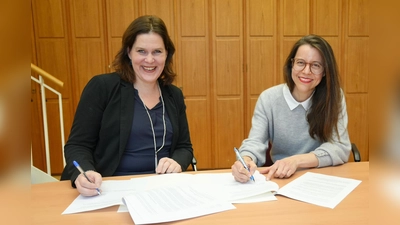 Die Aufsichtsratsvorsitzende der Münchner Volkshochschule, Verena Dietl, und Marina May (r.) unterzeichnen Mays Vertrag als neue Programmdirektorin der MVHS.  (Foto: LHM)