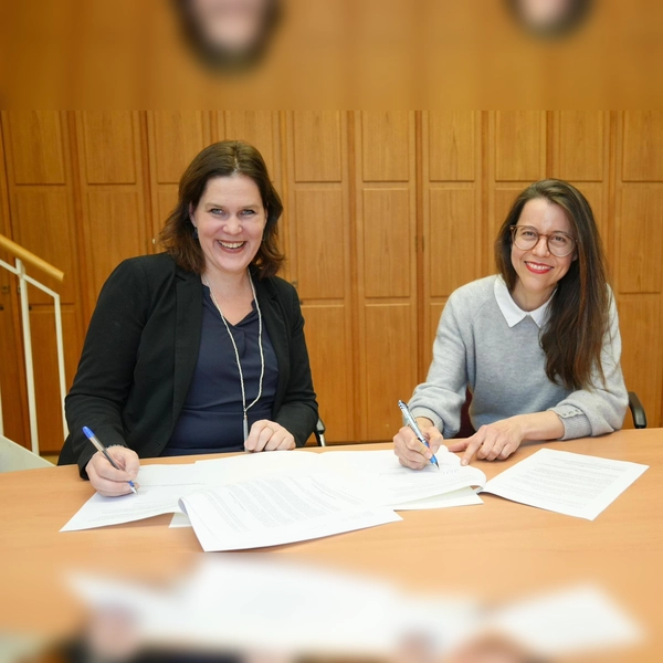 Die Aufsichtsratsvorsitzende der Münchner Volkshochschule, Verena Dietl, und Marina May (r.) unterzeichnen Mays Vertrag als neue Programmdirektorin der MVHS.  (Foto: LHM)