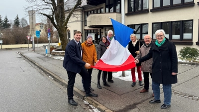 Bürgermeister Ludwig Horn (links) und Mitglieder des Freundeskreises Tutzing-Bagnères-Balatonkenese halten die französische Flagge anlässlich des 50. Jubiläums der Städtepartnerschaft zwischen Tutzing und Bagnères-de-Bigorre hoch. (Foto: Gemeinde Tutzing)