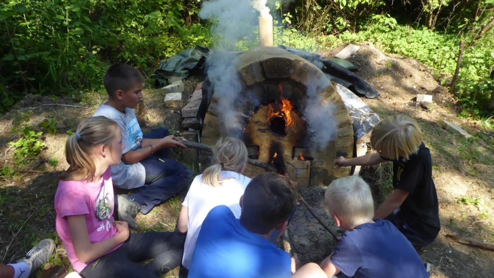 Nach getaner Arbeit kann man sich gemütlich um den Backofen setzen und zuschauen, wie das Brot langsam fertig wird.  (Foto: EKP)