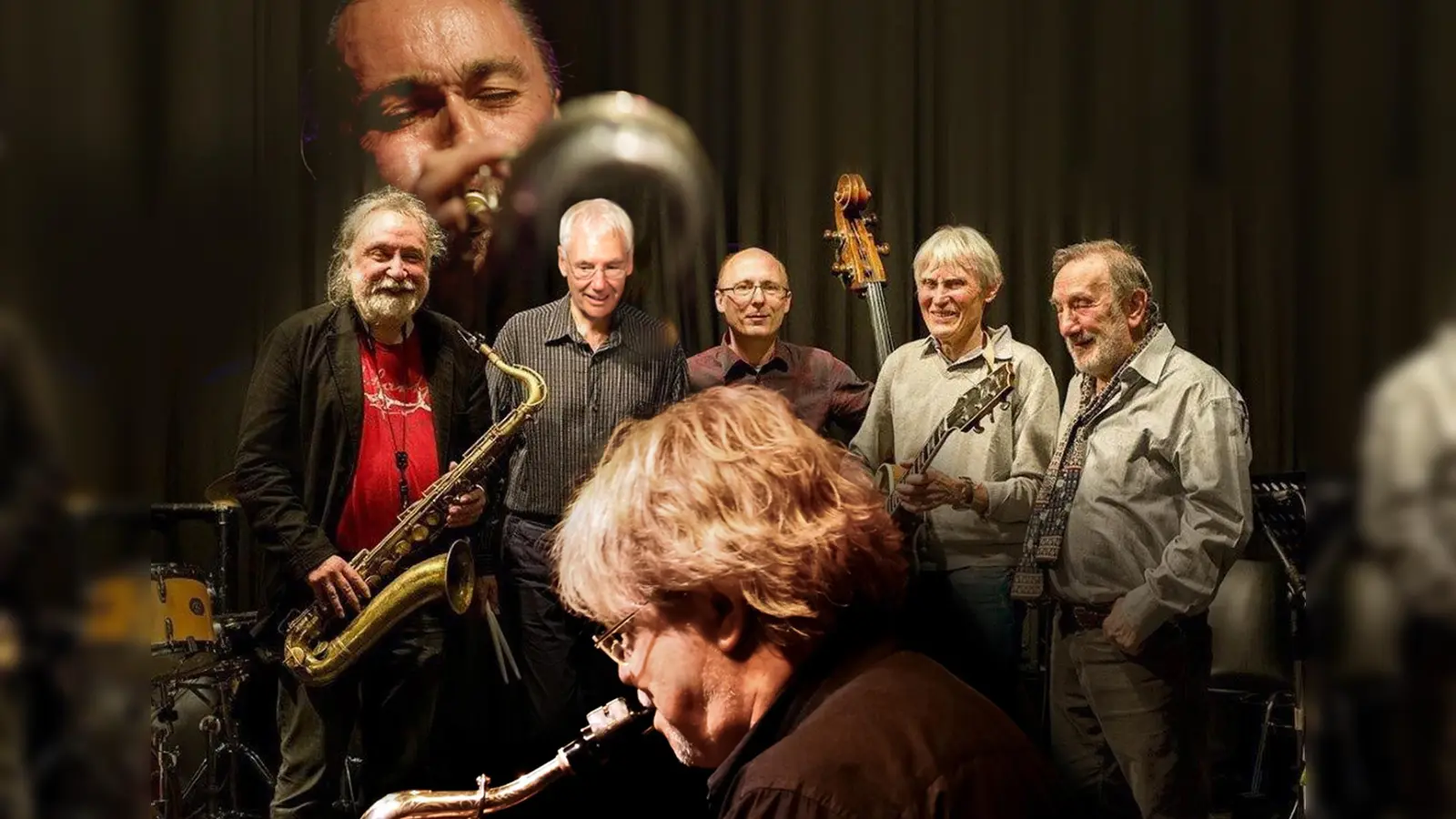 Das „Blue Monday Jazzquintett“ spielt als Eröffnungsband bei der Jamsession. Mit Ralf Peter Fuchs (sax), Franz Freudenreich (g), Gerhard Uttenthaler (b), Misha Shizz (p) und Horst Schroers (dr) vom Quintett spielen Leszek Zadlo (sax) (vorne im Bild) und Peter Tuscher (tr) (als Projektion im Bildhintergrund). (Foto: Rainer Ortag)