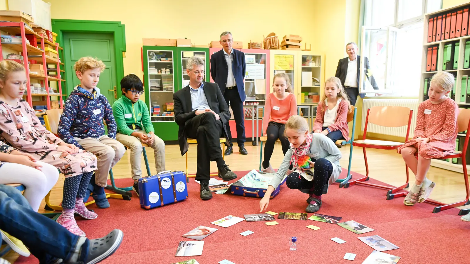 Kultusminister Michael Piazolo (m.), diskutiert bei der Präsentation des neuen Wertereisekoffers der Bayerischen Landeszentrale für politische Bildungsarbeit mit Grundschulkindern aus der Aubinger Limesschule. (Foto: Tobias Hase / StMUK)