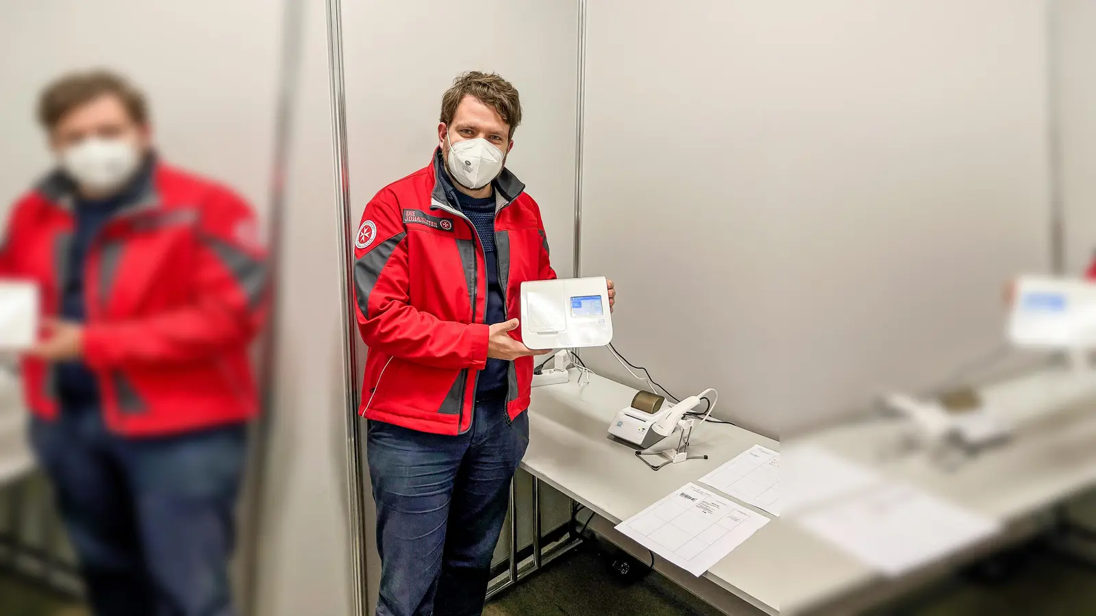 Kein langes Warten mehr aufs Testergebnis: Florian Weber, Leiter des Schnelltestzentrums der Johanniter im Olympiapark in München, zeigt eines der neuen molekulardiagnostischen Testsysteme für die Testauswertung. (Foto: Johanniter/Jason Podt)