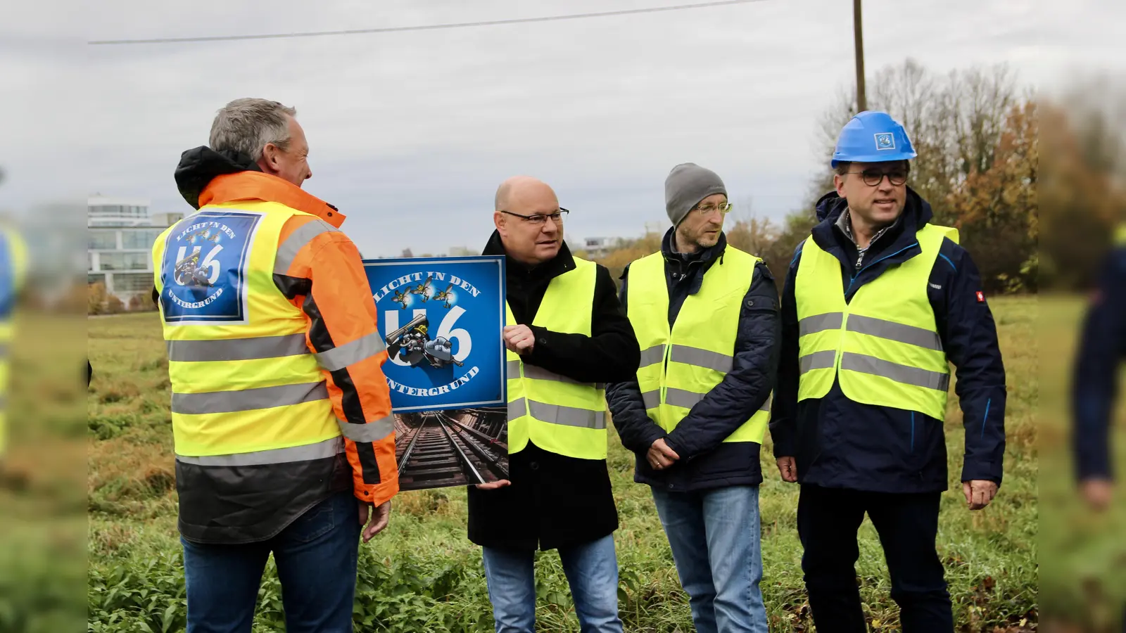 Comic für gute Kommunikation: Am Rande der künftigen Großbaustelle präsentieren Gemeinde und Bauverantwortliche das Logo für dei U-Bahnverlängerung: einen kleinen Maulwurf mit Bauplänen. V.l. Jörg Wüst als verantwortlicher Projektleiter des Bauunternehmens Leonhard Weiss, Bürgermeister Hermann Nafziger, Dimitri Steinke vom Projektmanagement und Stefan Schaudig von der Verwaltung (v.l.). (Foto: us)