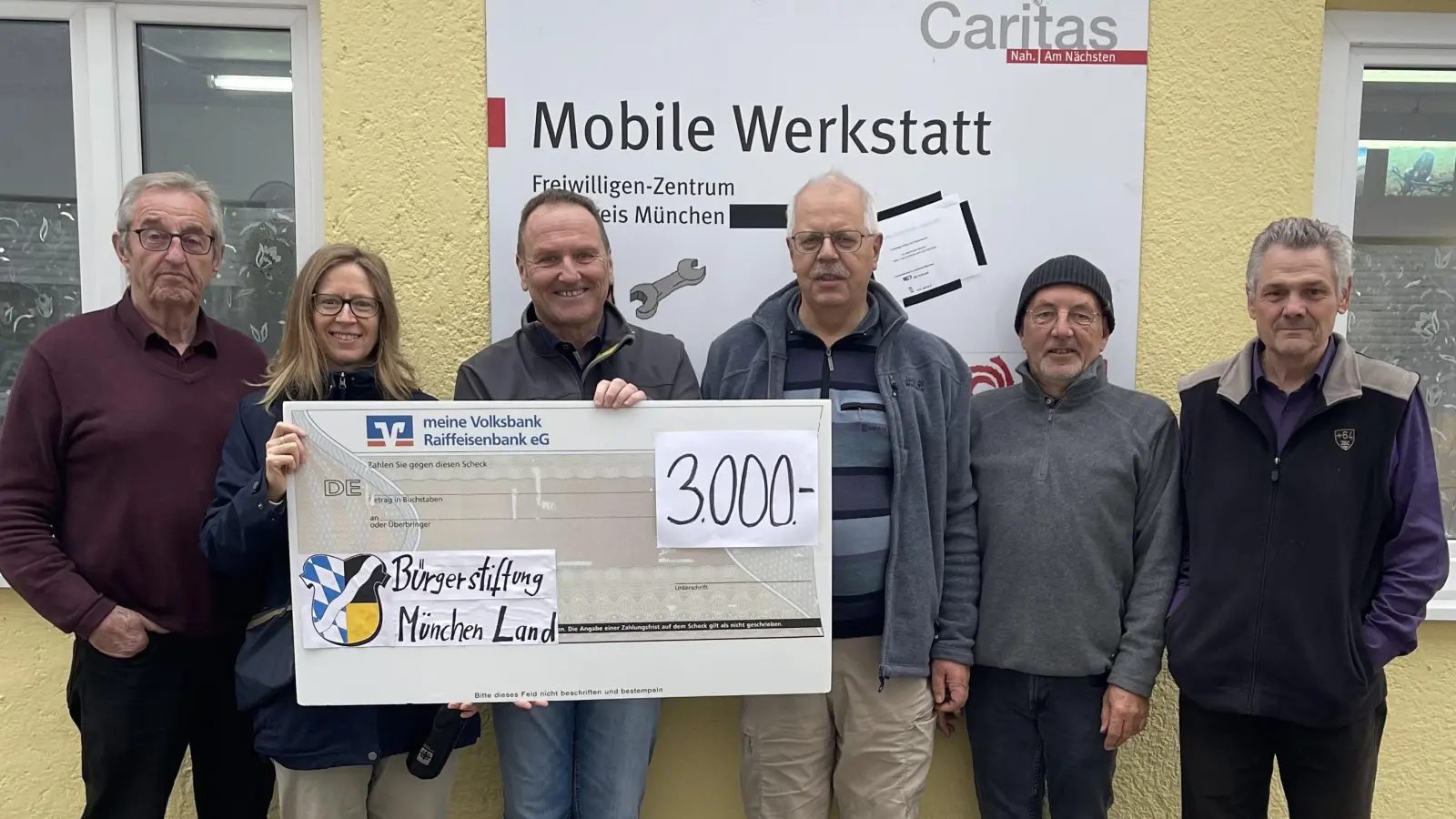 Die Mobile Werkstatt der Caritas, vertreten durch die Leitung Bettina Händel, die ehrenamtlichen Handwerker (l.) Erwin Scharl, und (2.v.r.) Kurt Kriegbaum und (r.) Karl-Heinz Zeidler, bekamen vom Vorstand der Bürgerstiftung München Land, repräsentiert durch Thomas Klement (3.v.l.) und Lothar Lauterbach (3.v.r.) einen stolzen Spendenscheck überreicht.  (Foto: hw)