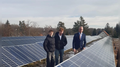 Die Schüler Bastian Stockmair und Victor Schopf sowie Schulleiter Alexander Schröder (von links) an der Solaranlage, die nun ausschließlich Strom fürs Gymnasium produzieren wird. (Foto: C.Jans)