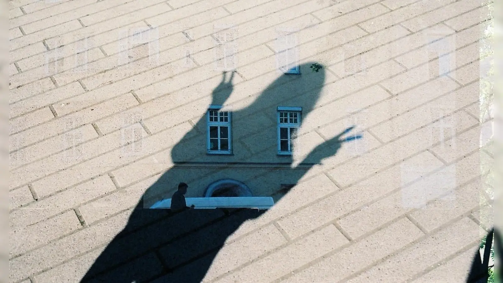 Eine Fassade trifft auf einen Schatten am Boden: Eine Fotografie, die doppelt Belichtet wurde. (Foto: Kulturzentrum LUISE)