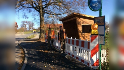 Die Betriebshofmitarbeiter Christoph Schrott und Josef Penzkofer haben das neue Buswartehäuschen im Ortskern von Landstetten aufgestellt. (Foto: Stadt Starnberg)