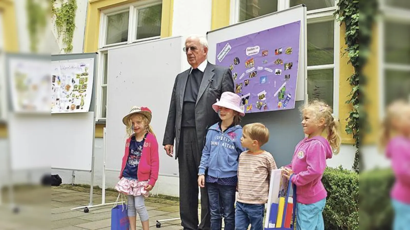 Weihbischof Engelbert Siebler mit den Kindern des Kindergartens Mintraching vor ihrer Collage.  (Foto: VA)