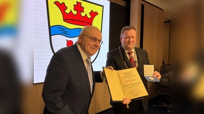 Bürgermeister Peter Köstler (r.) überreichte die silberne Bürgermedaille, die Ehrenurkunde und Anstecknadel an Günter Roll. (Foto: Ulrike Seiffert)