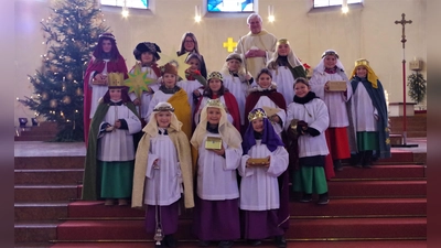 Pfarrer Christian Hermann und Gemeindeassistentin Elisabeth Nauderer mit den 15 Sternsingern, die am Dreikönigstag den Gottesdienst in St. Rupert besuchten.  (Foto: Beatrix Köber)