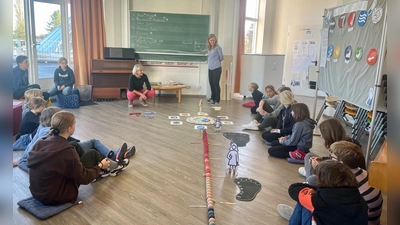 Kerstin Steuer (l.) und Heike Fliegenbauer bei einer Besprechung mit der Umweltgruppe. In der Mitte liegt die Temperaturkette, an der die Klimaerwärmung deutlich sichtbar wird. (Foto: Brigitte Bothen)