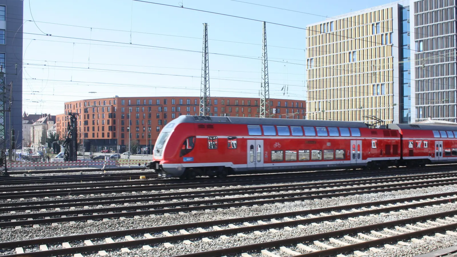 Direkt unter der Spitze dieses Zuges wird einmal die Umweltverbundröhre die Schienen unterqueren. An diesem Wochenende finden Vermessungen, Suchschachtungen, Kabeltiefbauarbeiten, etc. im Bereich der drei südlichen Gleise (Fernzuggleise München-Augsburg und südliches Verbindungsgleis) zur Vorbereitung der Umweltverbundröhre statt. Diese wird einmal vom Laimer Kreisel aus neben dem Steakhouse eine neue Verbindung für den ÖPNV, Radfahrer und Fußgänger nach Nymphenburg sein. Die Arbeiten finden durchgehend von Freitagabend bis Montagmorgen (25.-28. März) statt.<br> (Foto: Johannes Beetz)