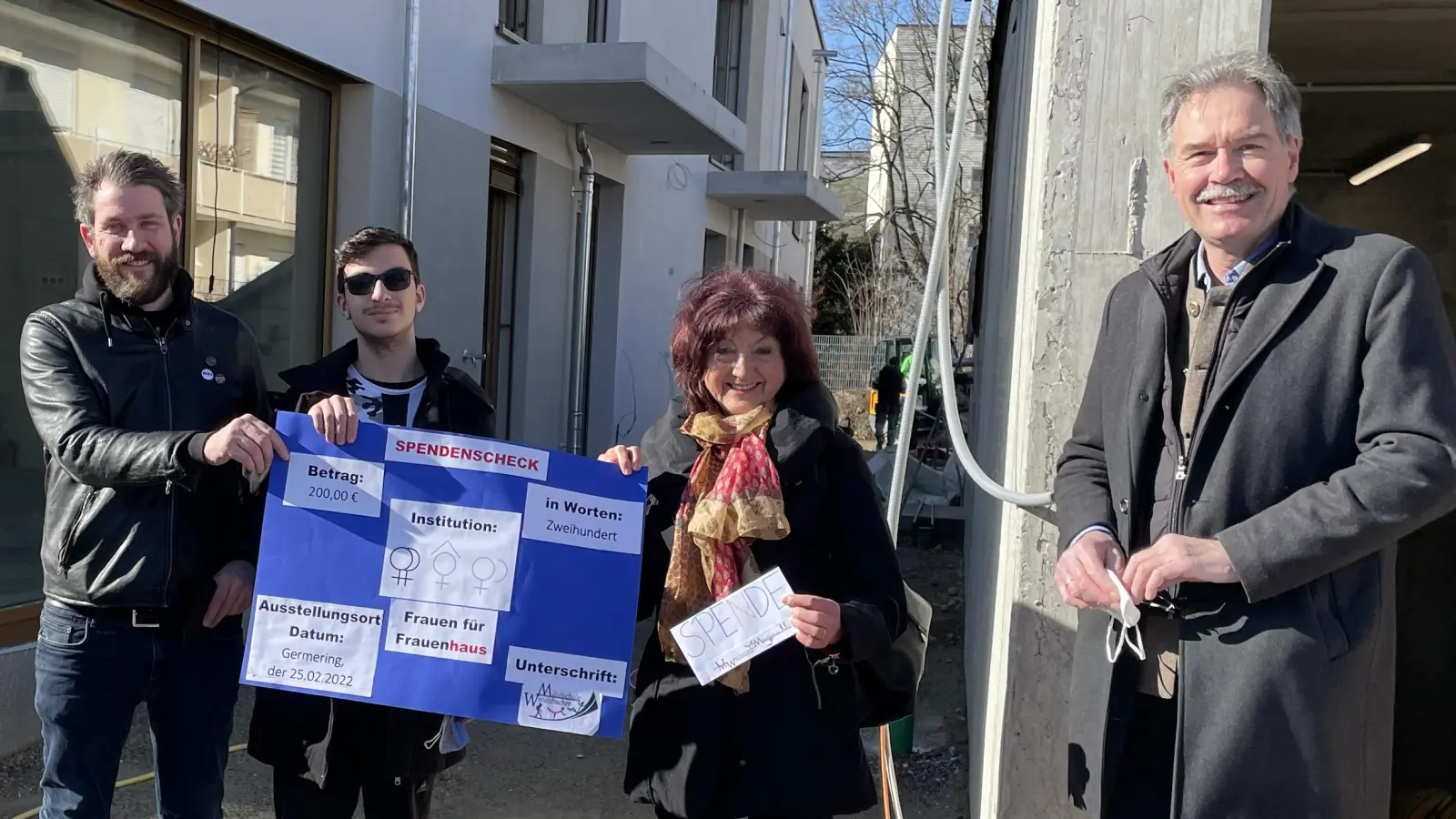 Lehrer Christian Rupp und 2. Schulsprecher Felix Domin (v.l.) überreichen auf der Baustelle des Frauenhauses eine Spende an die Stiftungsvorstände Eleanor Reis und Christian Ganslmeier. (Foto: pst)