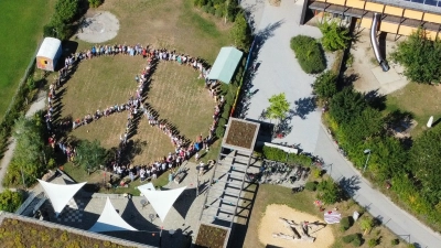 Beim ihrem Sommerfest stellten sich Schüler, Pädagogen und Eltern zu einem großen Peace-Zeichen auf. (Foto: Sch)