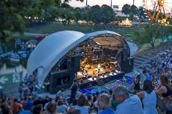 Im Olympiapark finden in August zeitgleich zwei tolle Veranstaltungen statt: das Sommerfestival, von dem hier das Riesenrad zu sehen ist, und der kostenlose MusikSommer auf der Seebühne. Foto: Martin Hangen/ Olympiapark München